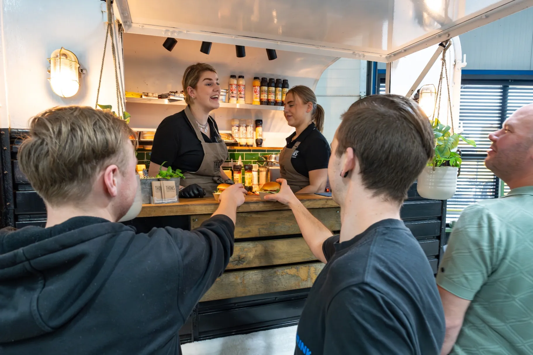 Gasten halen eten bij een foodtruck op het eigen terrein tijdens het jubileum van Slijptechniek Enter en Euromec